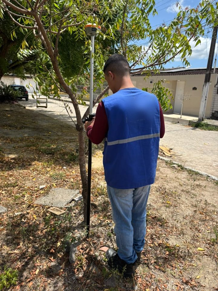 Membro da Nortear posicionando receptor GNSS sobre um ponto